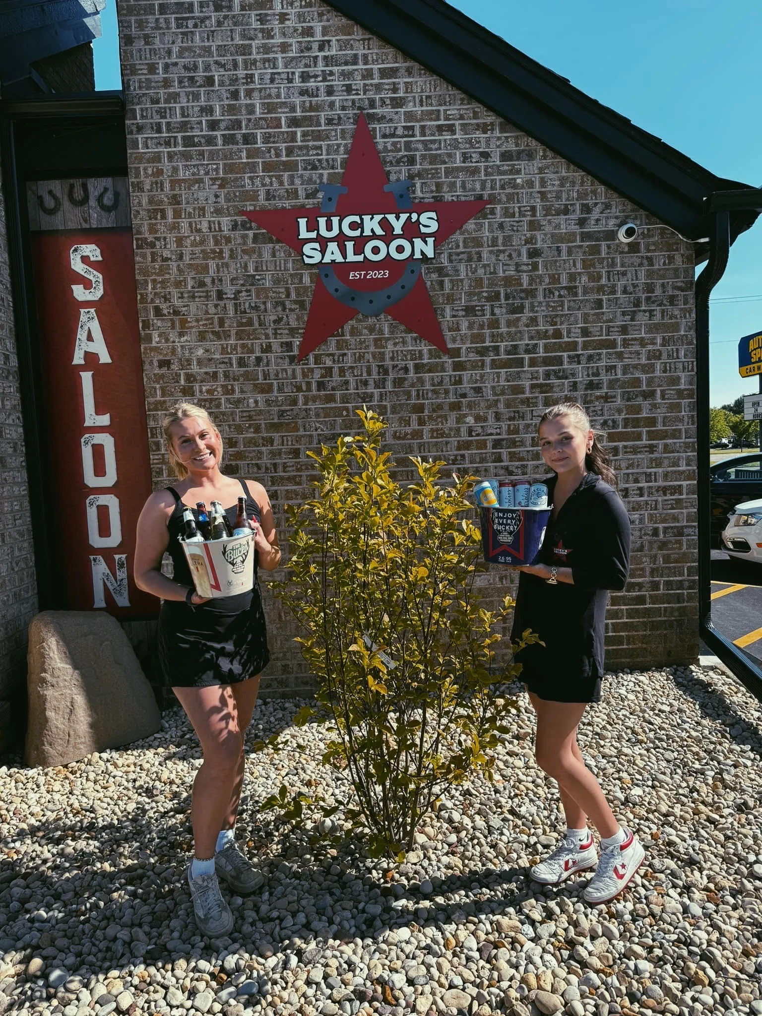 Lucky’s Saloon staff outside the building’s wall sign
